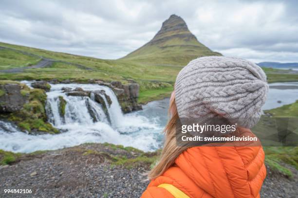 jeune femme en islande contempler les chutes d’eau et de la célèbre montagne kirkjufell - islande du centre ouest photos et images de collection