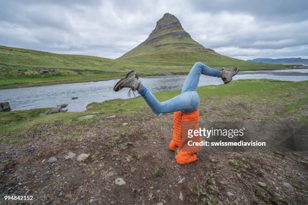 young woman exercising yoga headstand pose in nature at famous kirkjufell mountain, iceland - west central iceland stock pictures, royalty-free photos & images