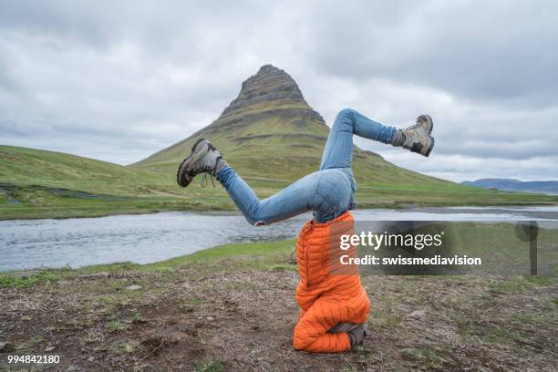 young woman exercising yoga headstand pose in nature at famous kirkjufell mountain, iceland - west central iceland stock pictures, royalty-free photos & images