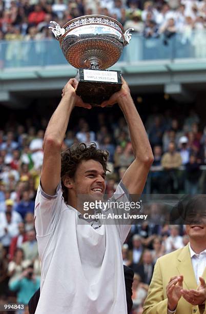 Gustavo Kuerten of Brazil celebrates with the trophy after winning his Mens final match against Alex Corretja of Spain during the French Open Tennis...