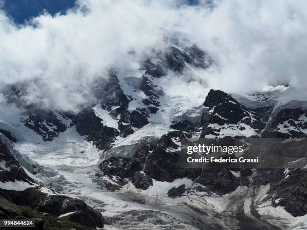 a glimpse of monte rosa among the clouds - pennine alps stock pictures, royalty-free photos & images
