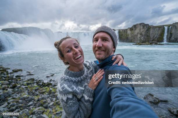 paar portretje van de selfie met prachtige waterval in ijsland, valt godafoss. mensen reizen exploratie concept - northeast iceland stockfoto's en -beelden