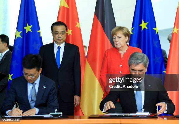 Of Siemens Joe Kaeser and President of Alibaba Cloud Computing Simon Hu sign an agreement as they attend a signing ceremony within the 5th...