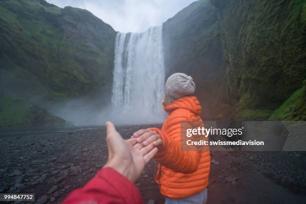 follow me to the waterfall, girlfriend leading man to godafoss falls in iceland - follow me stock pictures, royalty-free photos & images