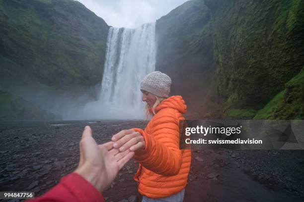 follow me to the waterfall, girlfriend leading man to godafoss falls in iceland - follow me stock pictures, royalty-free photos & images