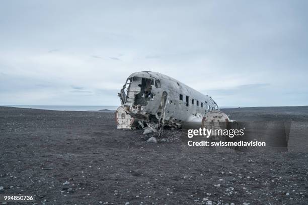 flugzeug wrack am strand island vor dramatischen himmel, dc3 marine flugzeug - swissmediavision stock-fotos und bilder