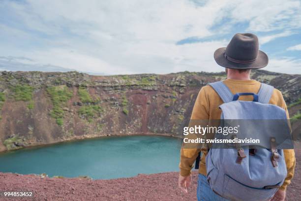 junger mann in island betrachtung kratersee von oben drauf - see crater lake stock-fotos und bilder