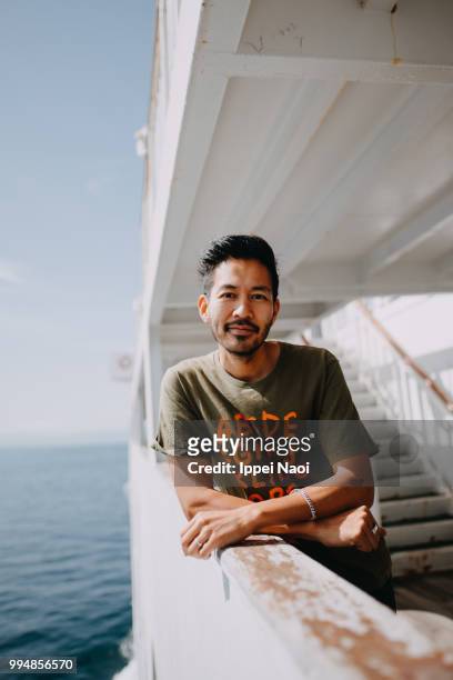Portrait of Japanese man smiling at camera on ferry deck