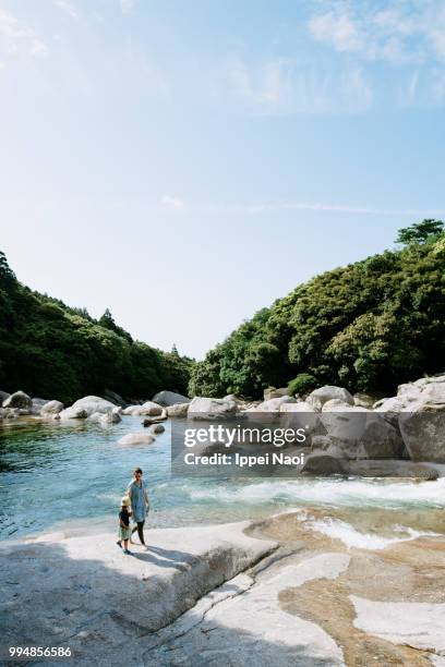 mother and child walking by idyllic river, yakushima, kagoshima, japan - ippei naoi fotografías e imágenes de stock