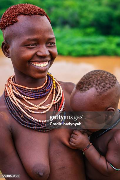 young mother from karo tribe breastfeeding her baby, ethiopia, africa - karo stock pictures, royalty-free photos & images