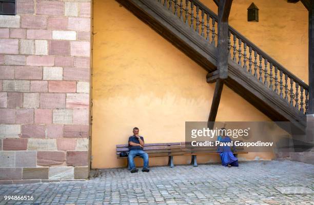 two indian tourists (a man and a woman) resting on a bench in nuremberg's castle, germany - pavel gospodinov 個照片及圖片檔