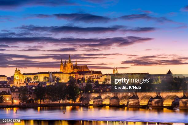 view of charles bridge, st. nicholas church, and castle of st. vitus cathedral at sunset time with reflection on water in river in prague (praha), czech republic, europe, where is the most visiting place from tourist for travel - st nicholas church stock-fotos und bilder