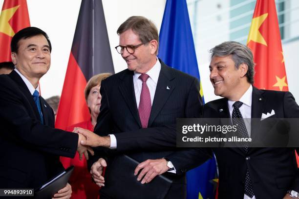 July 2018, Germany, Berlin: An Jin, Jochen Heizmann and Luca de Meo signing a contract during the 5th German-Chinese government consultations at the...