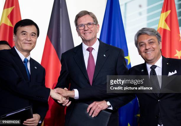 July 2018, Germany, Berlin: An Jin, Jochen Heizmann and Luca de Meo signing a contract during the 5th German-Chinese government consultations at the...