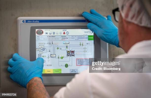 An employee makes adjustments to a computer panel controlling milk pasteurization at the Nicasio Valley Cheese Co. Facility in Nicasio, California,...