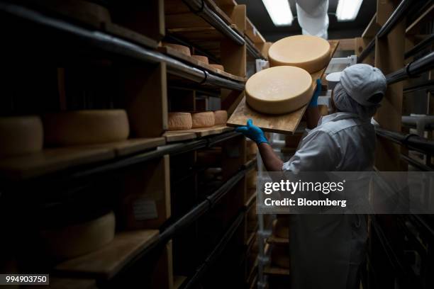 An employee places San Geronimo organic cheese wheels on shelves at the Nicasio Valley Cheese Co. Facility in Nicasio, California, U.S., on Friday,...