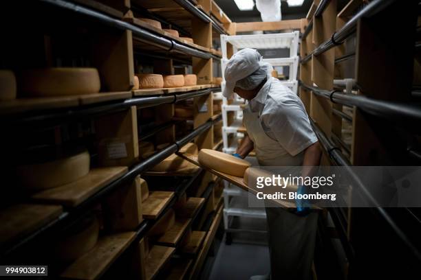 An employee places San Geronimo organic cheese wheels on shelves at the Nicasio Valley Cheese Co. Facility in Nicasio, California, U.S., on Friday,...