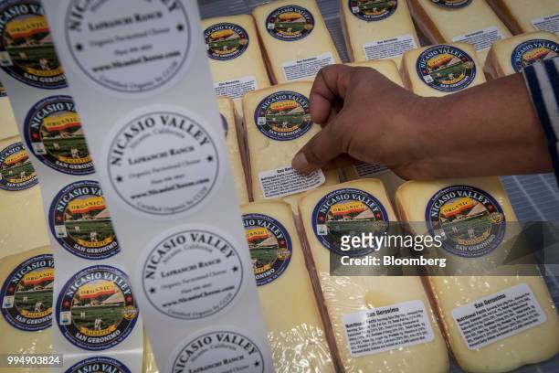An employee labels packages of San Geronimo cheese at the Nicasio Valley Cheese Co. Facility in Nicasio, California, U.S., on Friday, July 6, 2018....