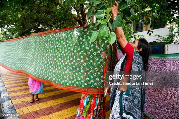 People from Warkari community dry their clothes near Balgandharva Rangamandir as the Paalkhi procession halted for 1 day on July 8, 2018 in Pune,...