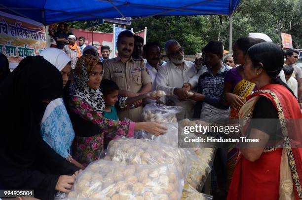 Muslim volunteers of Rijwani Masjid, Talwar Wabut trust and young circle distributed Laddoo's to Pilgrims at Ganj peth on July 8, 2018 in Pune,...