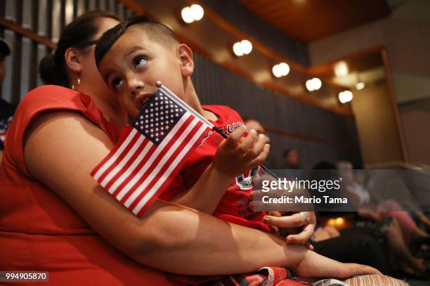 Young U.S. Citizen Sergio Montana originally from Mexico, holds an American flag during a citizenship celebration for young people conducted by U.S....