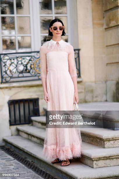 Erin O'Connor wears a pink lace mesh dress, sunglasses, a white bag , outside Dior, during Paris Fashion Week Haute Couture Fall Winter 2018/2019, on...