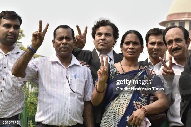 Asha Devi and Badrinath parents of Delhi gangrape rape victim show victory sign after Supreme Court verdict on 2012 Delhi Gangrape case on July 9,...