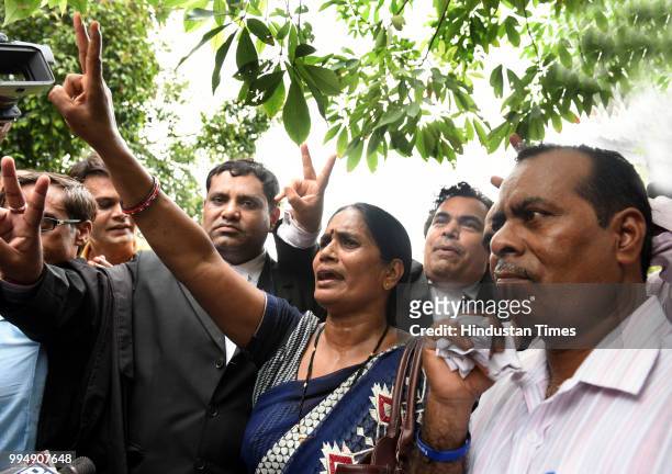 Asha Devi and Badrinath parents of Delhi gangrape rape victim show victory sign after Supreme Court verdict on 2012 Delhi Gangrape case on July 9,...