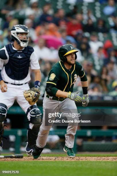 Jed Lowrie of the Oakland Athletics and catcher Grayson Greiner of the Detroit Tigers watch a RBI-double by Lowrie at Comerica Park on June 27, 2018...