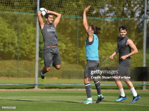 Henrikh Mkhitaryan, Carl Jenkinson and Hector Bellerín of Arsenal share a joke during a training session at London Colney on July 9, 2018 in St...