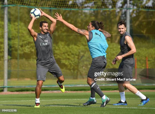 Henrikh Mkhitaryan, Carl Jenkinson and Hector Bellerín of Arsenal share a joke during a training session at London Colney on July 9, 2018 in St...