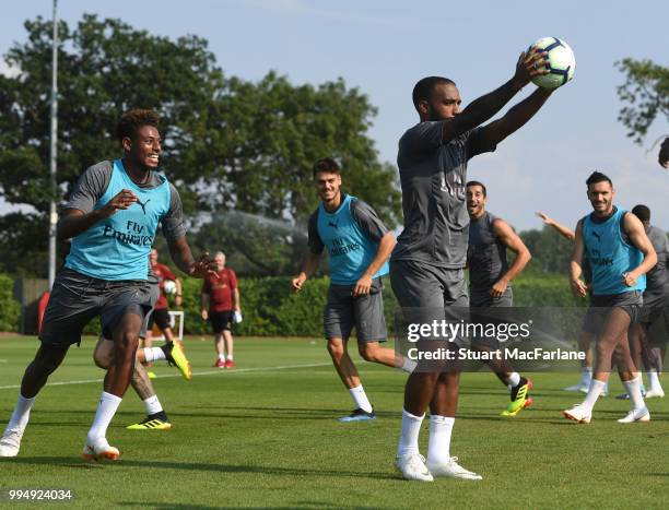 Jeff Reine-Adelaide and Alex Lacazette of Arsenal share a joke during a training session at London Colney on July 9, 2018 in St Albans, England.