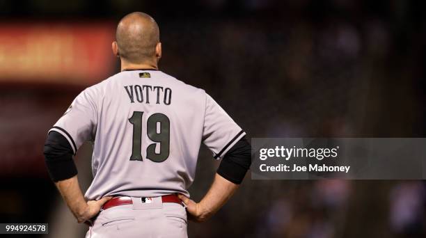 Joey Votto of the Cincinnati Reds stands along the baseline after grounding out against the Colorado Rockies at Coors Field on May 26, 2018 in...