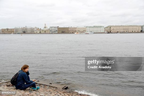 Woman sits along the Neva River in Saint Petersburg, Russia on July 09, 2018.