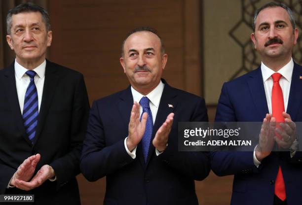 Turkey's Foreign Minister Mevlut Cavusoglu gestures as he listens to the speech of the president of Turkey, during a news conference at the...