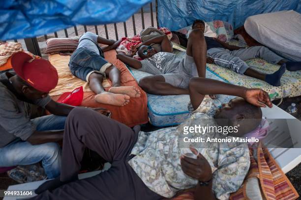 Migrants and refugees stay outside a building after being evicted 4 days ago by Italian Police, on July 9, 2018 in Rome, Italy. About 120 African...