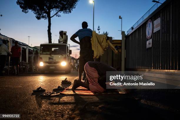 Migrants and refugees pray on a street outside a building after being evicted 4 days ago by Italian Police, on July 9, 2018 in Rome, Italy. About 120...