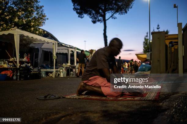 Migrants and refugees pray on a street after being evicted 4 days ago by Italian Police, on July 9, 2018 in Rome, Italy. About 120 African migrants...