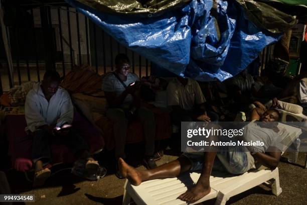 Migrants and refugees stay outside a building after being evicted 4 days ago by Italian Police, on July 9, 2018 in Rome, Italy. About 120 African...