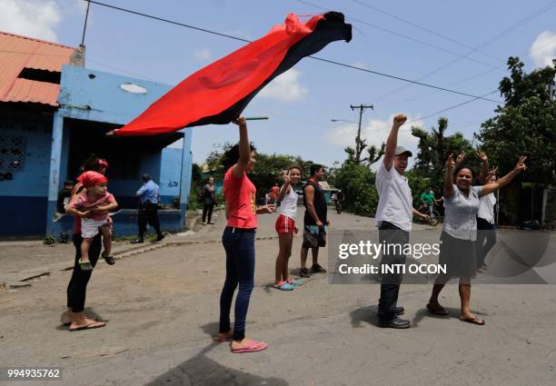 Supporters of under-pressure Nicaraguan President Daniel Ortega gesture and shout insults as a caravan of the Catholic Church, including cardinal...