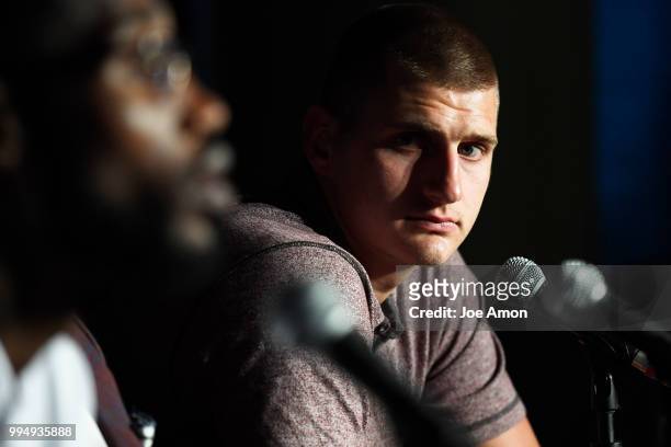Nikola Jokic listens to his teammate Will Barton during a press conference as the Nuggets to announce new contracts for them at the Pepsi Center on...