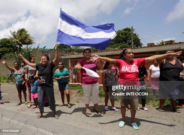 Woman waves a Nicaraguan flag as a caravan of the Catholic Church, including cardinal Leopoldo Brenes, passes by in Diriamba, Nicaragua, on July 9,...