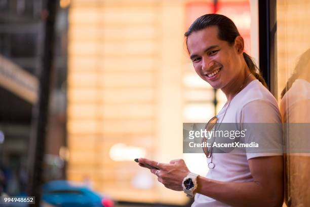 portrait of an asian man using his smart phone - bukit bintang stock pictures, royalty-free photos & images