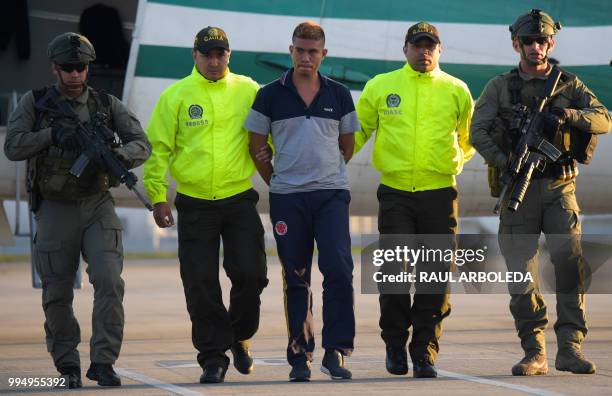 Colombian police escort Jesus Vargas, aka "Reinel", who was allegedly in charge of guarding the members of the news team from Ecuadorean newspaper El...