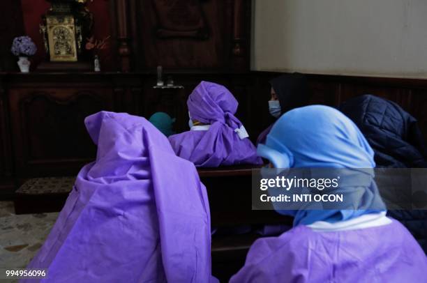 Women afraid of pro-government Sandinista youths cover themselves as they take shelter at the San Sebastian Basilica in Diriamba, Nicaragua, on July...