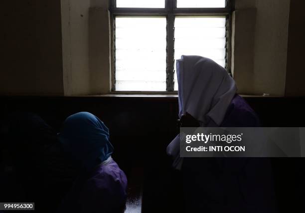 Women afraid of pro-government Sandinista youths cover themselves as they take shelter at the San Sebastian Basilica in Diriamba, Nicaragua, on July...