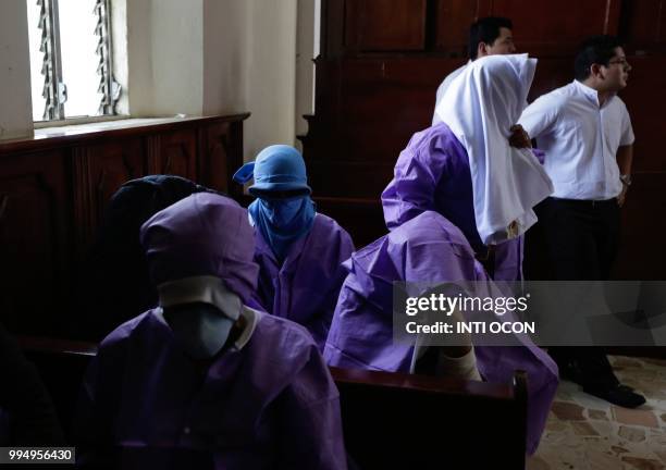 Women afraid of pro-government Sandinista youths cover themselves as they take shelter at the San Sebastian Basilica in Diriamba, Nicaragua, on July...