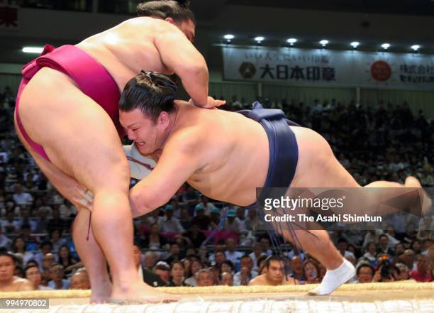 Sekiwake Mitakeumi throws Ikioi to win on day two of the Grand Sumo Nagoya Tournament at the Dolphin's Arena on July 9, 2018 in Nagoya, Aichi, Japan.