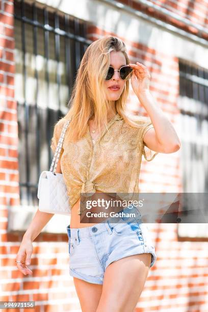 Joy Corrigan is seen wearing a Chasing Unicorns top, One Teaspoon jean shorts with Buffalo London sneakers in the Lower East Side on July 9, 2018 in...