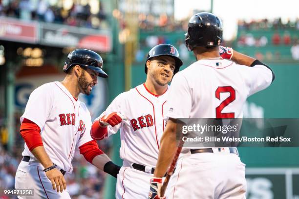 Steve Pearce of the Boston Red Sox reacts with J.D. Martinez and Xander Bogaerts after hitting a two-run home run during the first inning of a game...